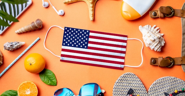 Accessories for beach holidays around a protective mask with the flag of the USA