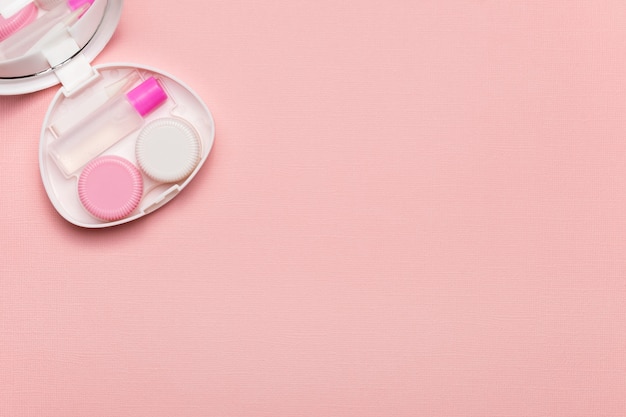 Accessories for contact lenses on a pink background