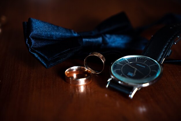 Photo accessories for men for wedding, groom in costume, belt, bow tie, wedding rings, bouquet and watches