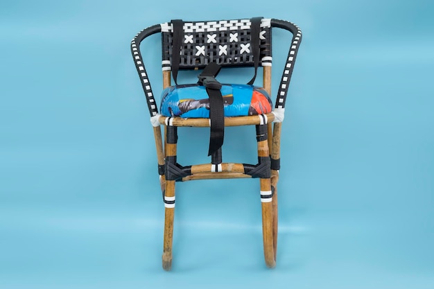 Accessory baby seat for motorcycle made of rattan isolated on blue background