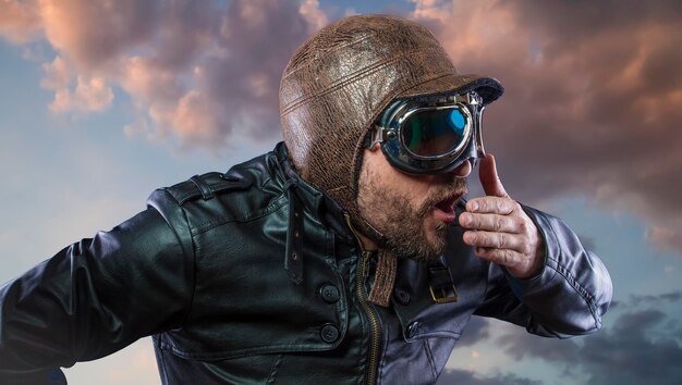 Accident, pilot of the 20s with sunglasses and vintage aviator helmet. Wears leather jacket, beard and expressive faces