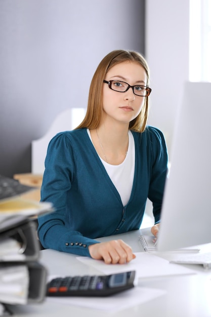 Photo accountant checking financial statement or counting by calculator income for tax form hands closeup