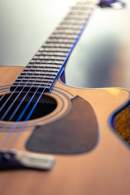 Acoustic guitar music instrument resting against a dark black background