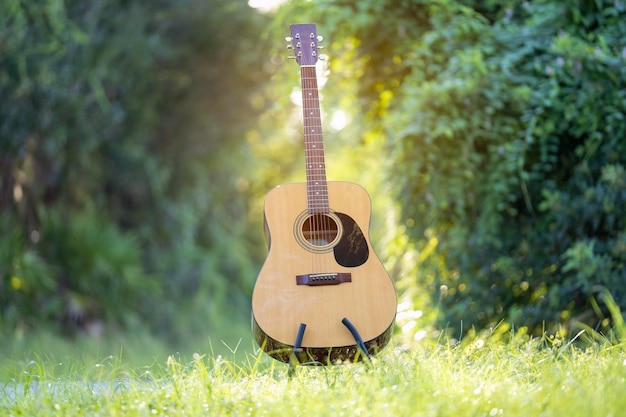 Acoustic guitar outdoors on greenery background Concept of calm music