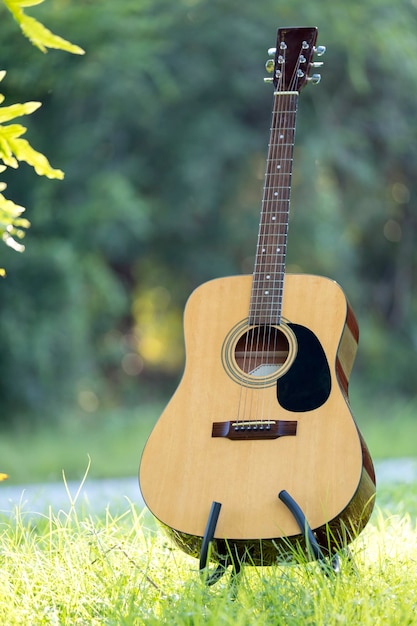 Acoustic guitar outdoors on greenery background Concept of calm music