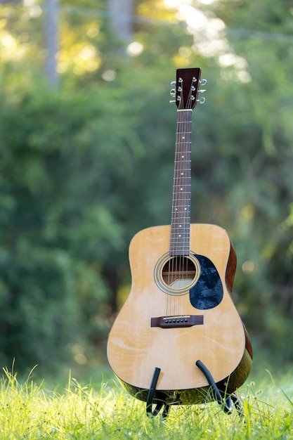 Acoustic guitar outdoors on greenery background Concept of calm music