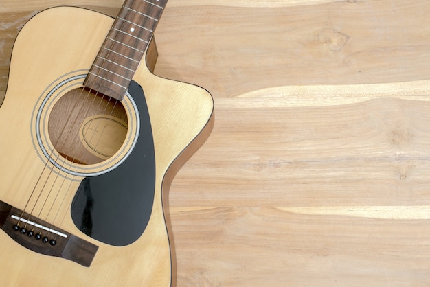 acoustic guitar on a wooden desk.