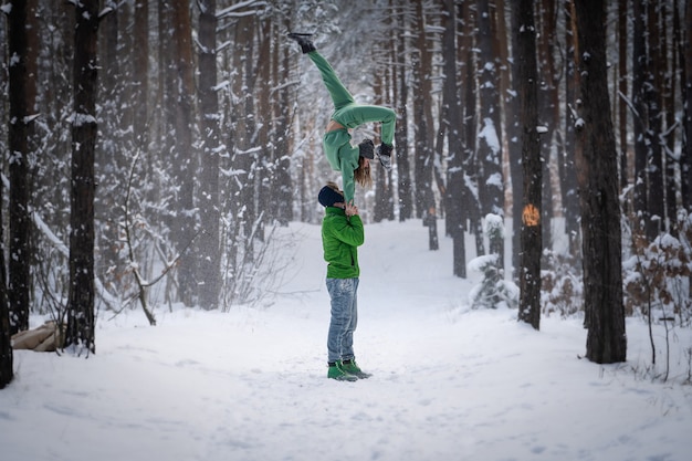 Acrobatic duo making nice pose in the snowy forest during the winter