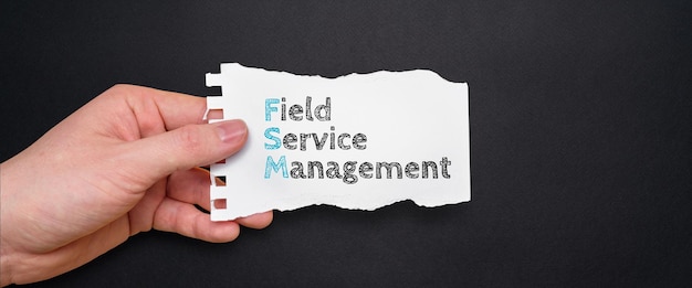 Acronym FSM or Field Service Management Person holding a piece of paper with text