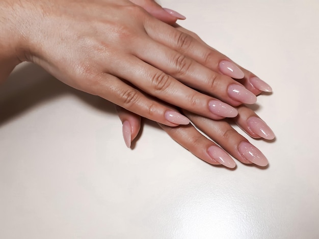 Acrylic nail extension manicure nail correction hands in the foreground Reflective design