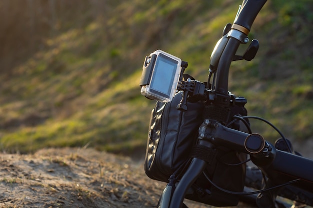 Action Camera on a bike with a bikepacking bag in a waterproof case against the backdrop of nature.