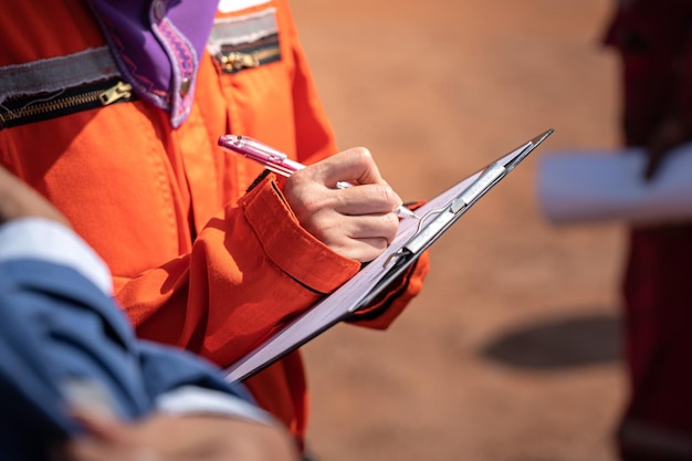 Action of safety officer is writing on safety checklist document during safety audit and inspection