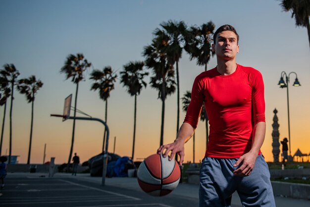 Action shot of young man playing basketball outdoors