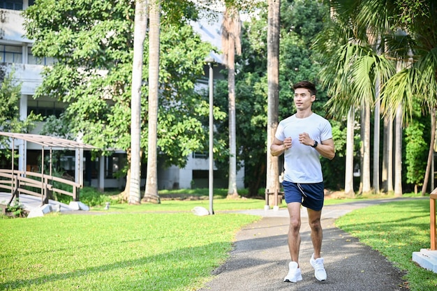 Active fit Asian man jogging in the city park in the morning Healthy lifestyle concept