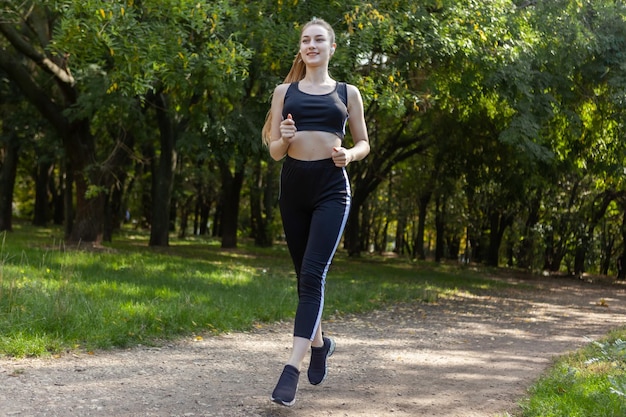 Active fit slim woman runner in sportswear is practicing jogging in the park Healthy lifestyle