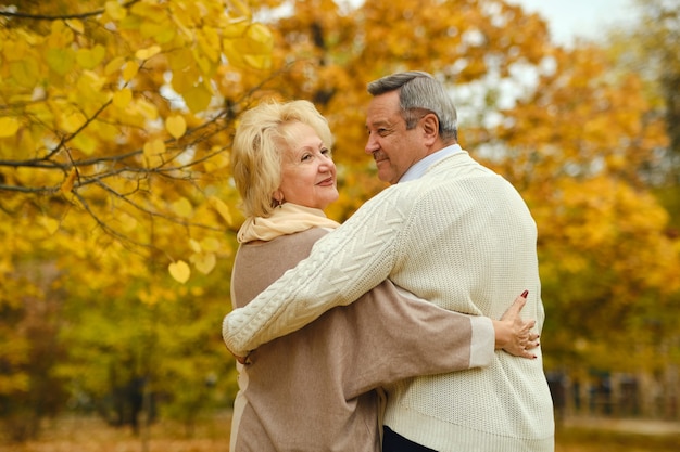 Active happy seniors walking in autumn park