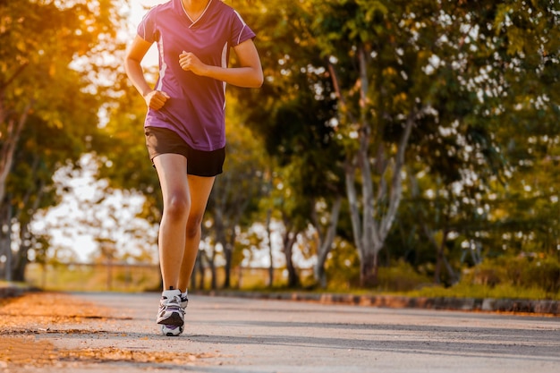 Active healthy runner jogging outdoor. Woman jogging at park in sunrise light