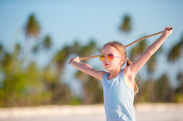 Active little girl on white beach having fun. Closeup kid background the sea