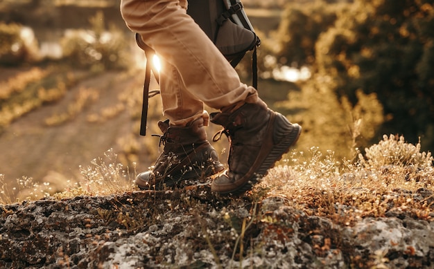 Active male backpacker in trekking boots walking on trail