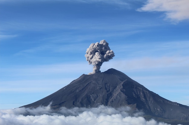 Active Popocatepetl volcano in Mexico against the blue sky