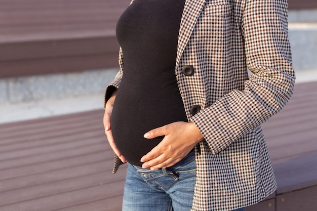 Active pregnancy concept closeup of belly of young business or student pregnant woman future mom