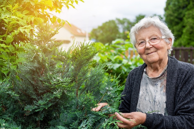 Active senior woman takes care of her huge garden