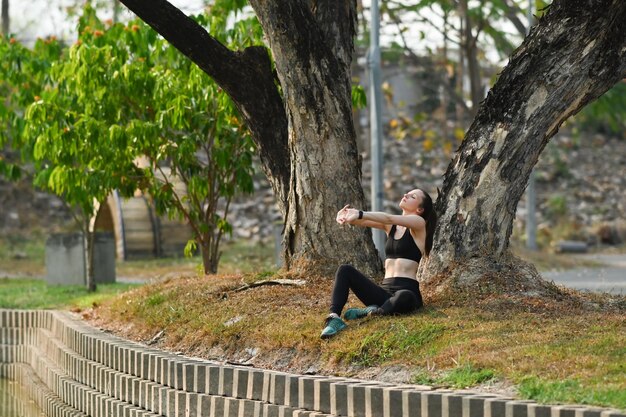 Active sporty caucasian female stretching exercises near river Healthy lifestyle sport and fitness concept