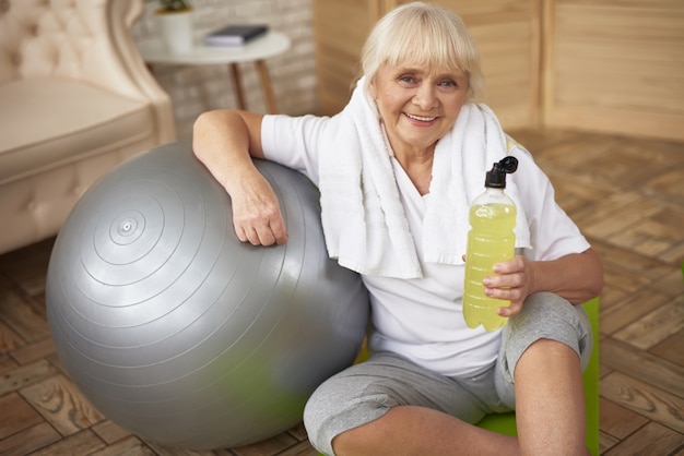 Active Sporty Old Lady Drinks Antioxidants Water.