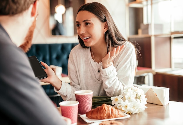 Active woman speaking with partner at table during lunch