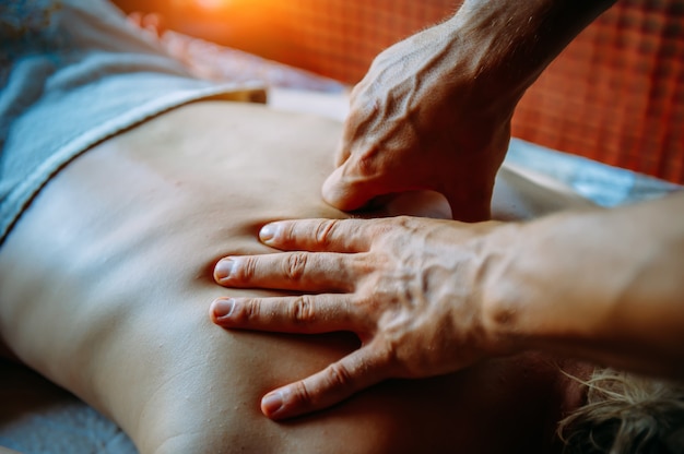 Acupressure massage in spa centre. Woman at acupressure back massage, masseur's hands close up. Body therapy for healthy lifestyle