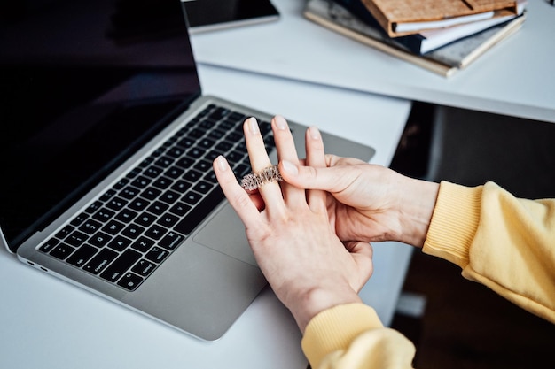 Acupuncture Su Jok sujok su jok sujok is traditional Chinese medicine therapy Sujok Pain Therapy Finger Massager Circulation Rings on female hands near laptop on workplace