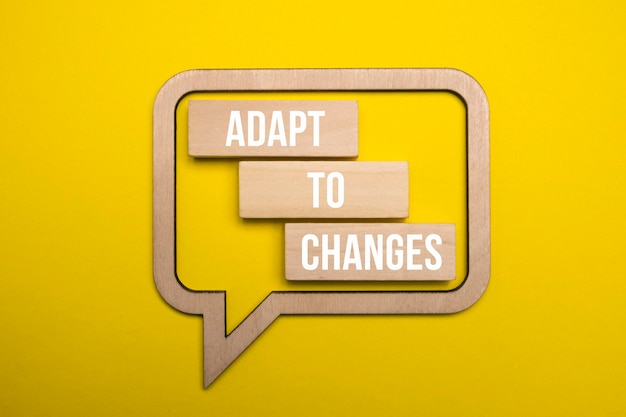 Adapt to changes word wooden blocks on yellow background