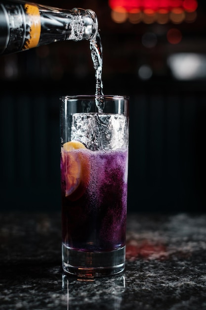 Adding soda in glass with ice Making refreshing cocktail