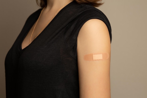 Adhesive bandage on an woman arm after vaccination