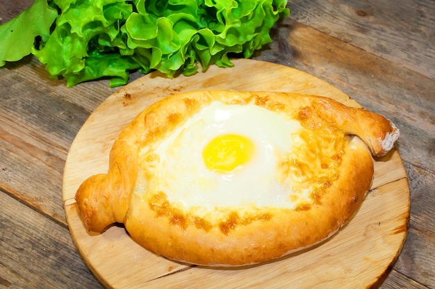 Adjara khachapuri bread on a board with cheese and egg