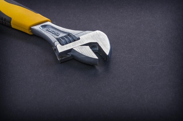 Adjustable wrench on black background