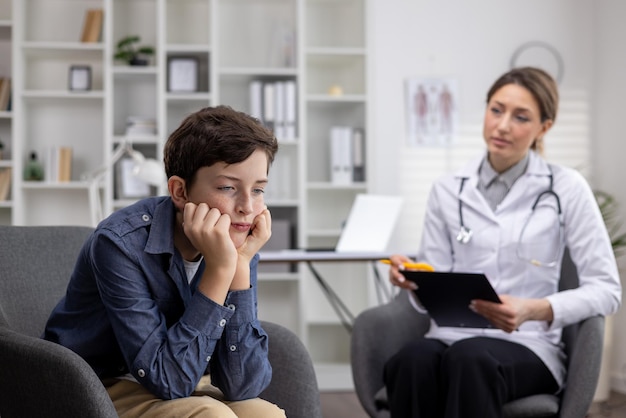 Admission of a young upset teenage boy to a pediatrician a female doctor asks a young teenager about