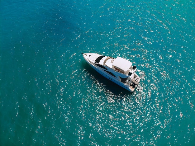 Adorable aerial top view photo of a laxury huge two-storey yach sailing across the deep blue sea