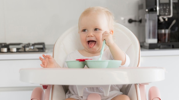 Adorable baby girl playing with food