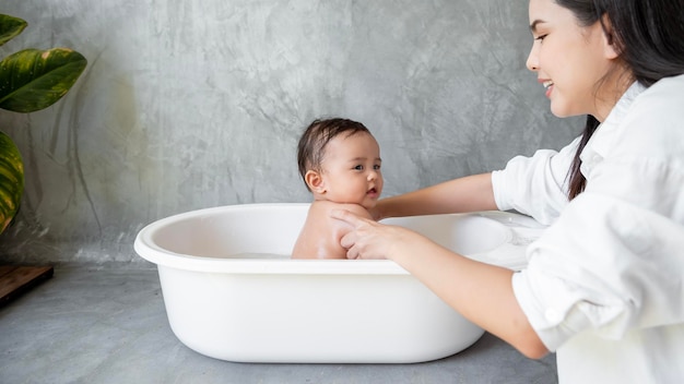 Adorable baby girl taking a bath with mother family child childhood and parenthood concept