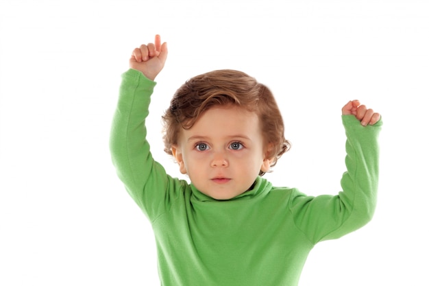 Adorable baby with green shirt raising a hand 