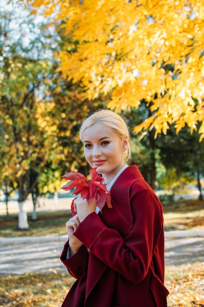 Adorable blonde fashion girl in fall Autumn park