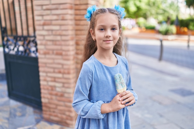 Adorable caucasian girl smiling confident eating ice cream at street