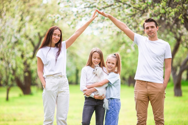 Adorable family in blooming cherry garden on beautiful spring day