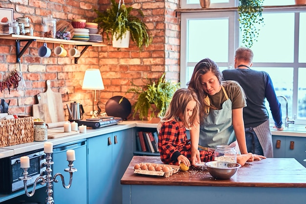 Adorable family together cooking breakfast in loft style kitchen.