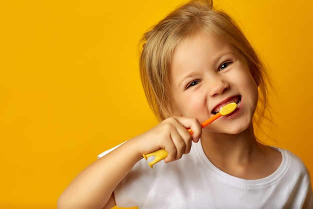 Adorable girl brushing teeth with kids toothbrush