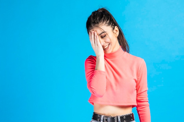 Adorable girl is smiling and put her hand to her face High quality photo