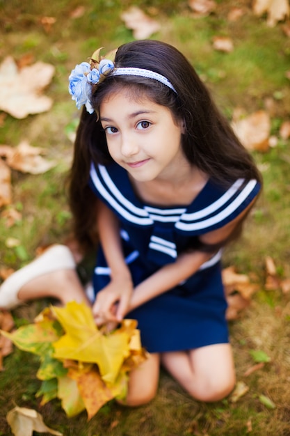 Adorable girl with yellow leaves