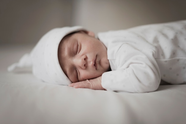 Adorable little baby sleeping on white sheets