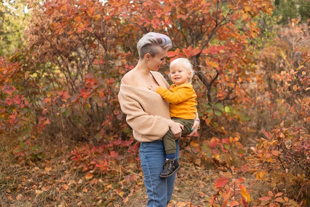 An adorable little boy with his mother in autumn park